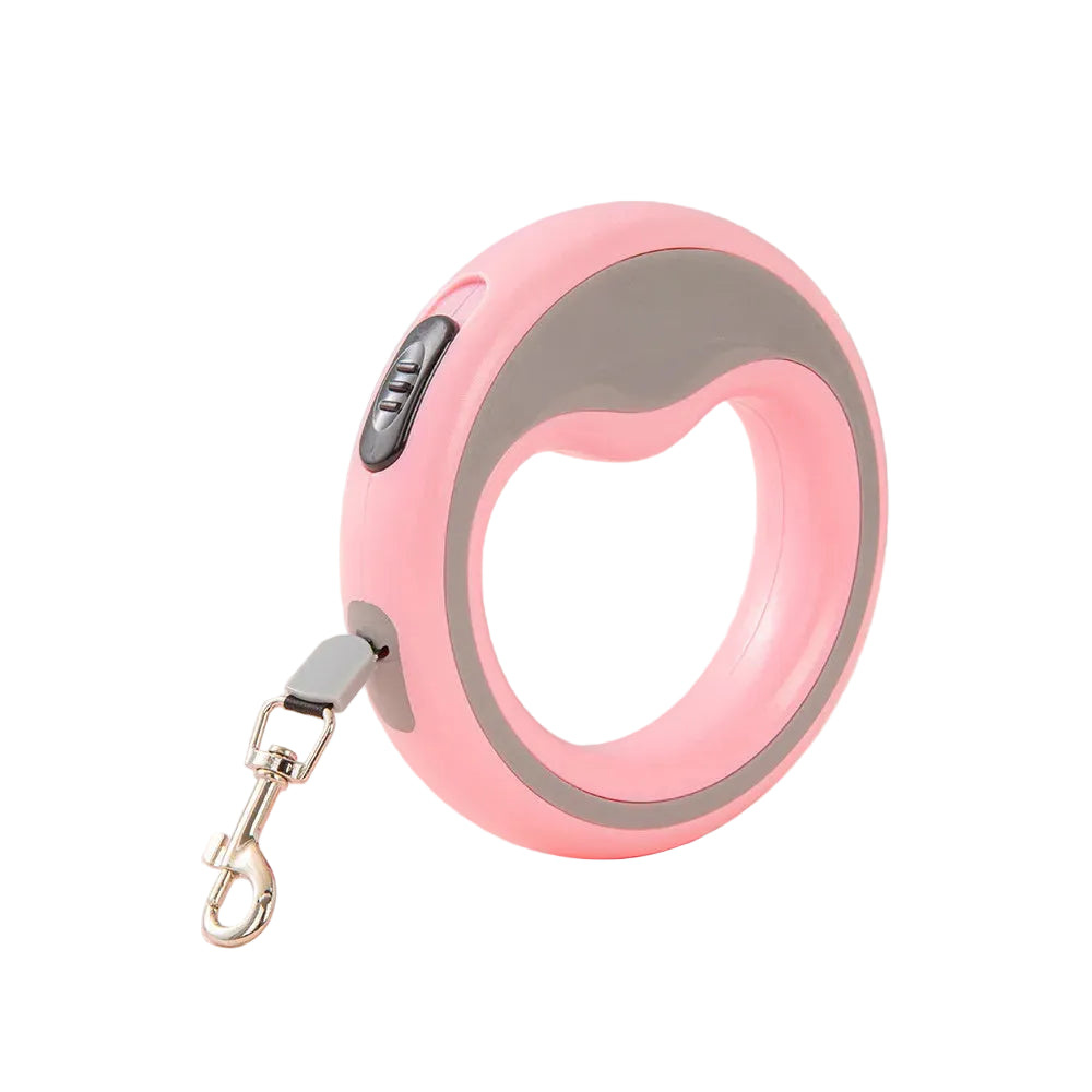 Pink retractable dog leash with gray accents on a light pink surface.